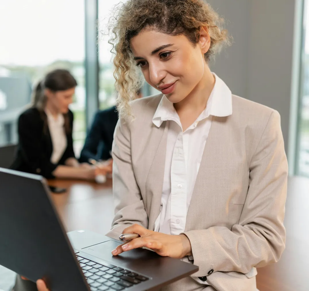 Frau arbeitet im Büro am Laptop