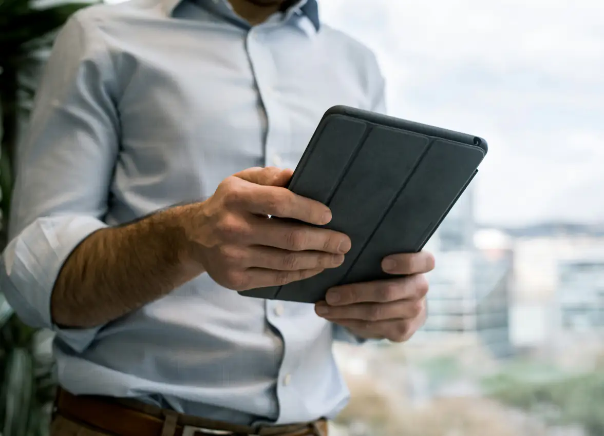 Mann im Hemd hält ein Tablet